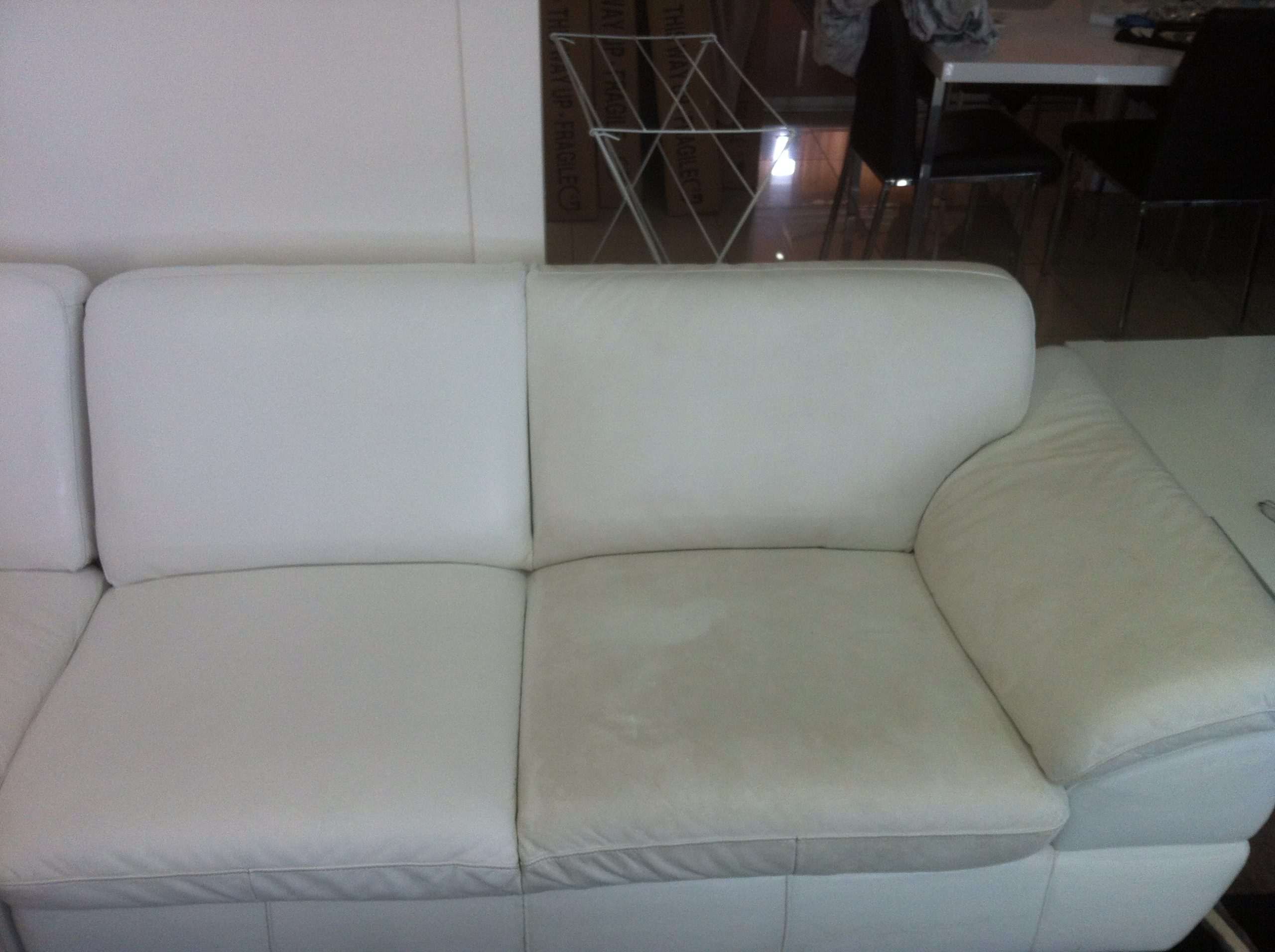 Half cleaned White leather couch by Priceless Carpet Cleaning